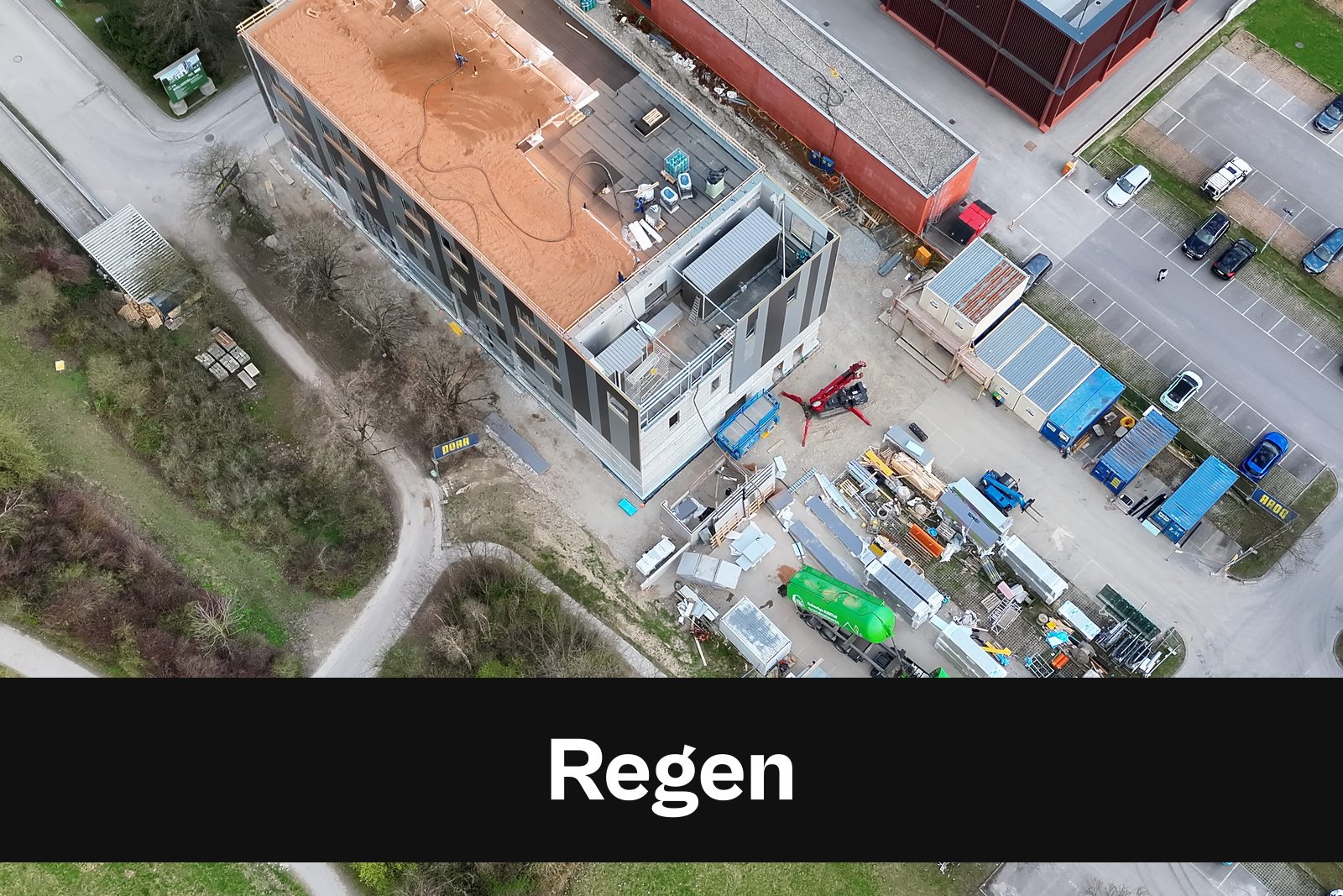 Drohnen-Luftaufnahme einer Baustelle in Regen mit Standort-Badge