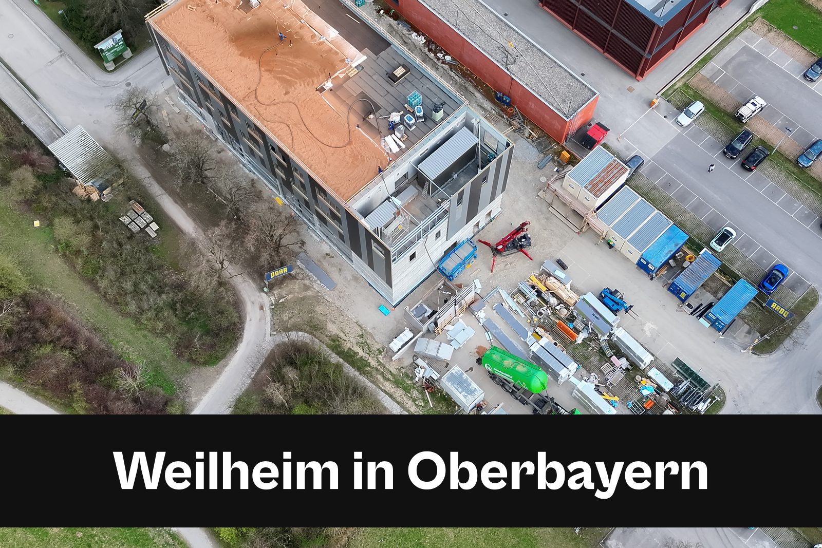 Drohnen-Luftaufnahme einer Baustelle in Weilheim in Oberbayern mit Standort-Badge